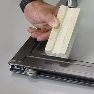 Carefully Using A Wood Block To Separate The Frame